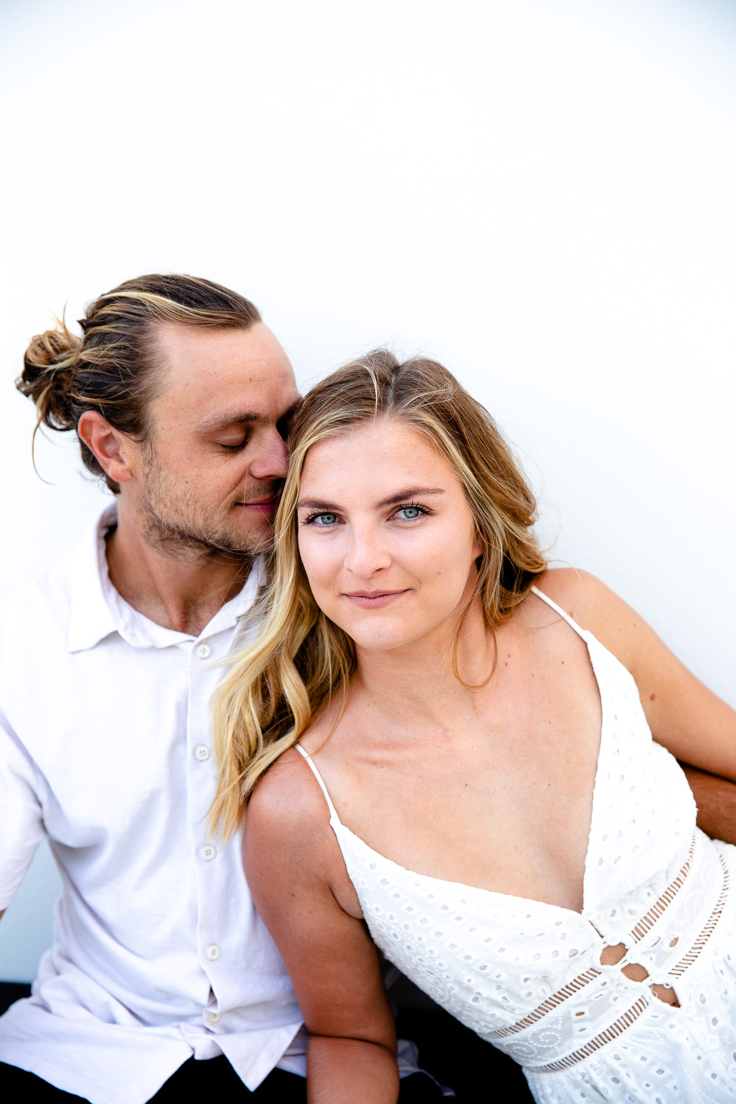 Couple posing in front of white wall during engagement session in Turks and Caicos