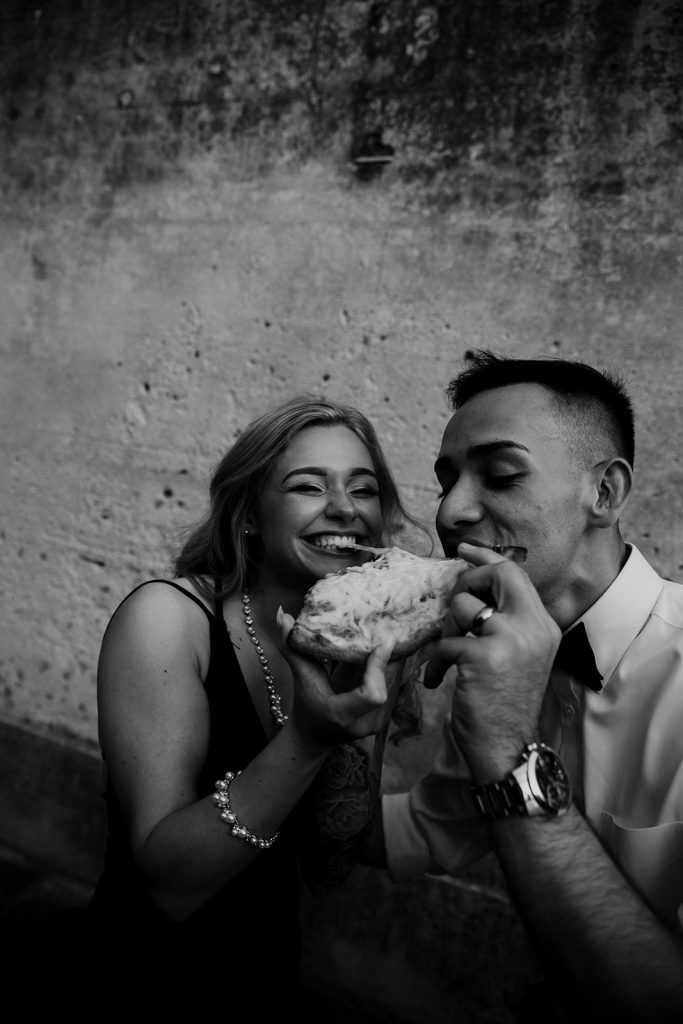 Couple taking a bit of their pizza at their engagement session