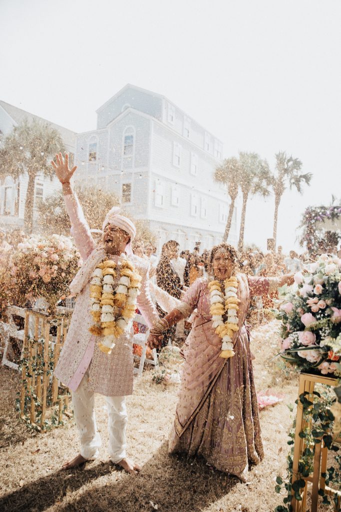Indian wedding in Charleston. Bride and groom walking down the aisle while it is raining flowers.