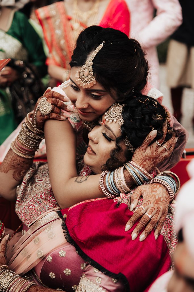 Intimate moment between bride and sister during traditional Indian wedding ceremony