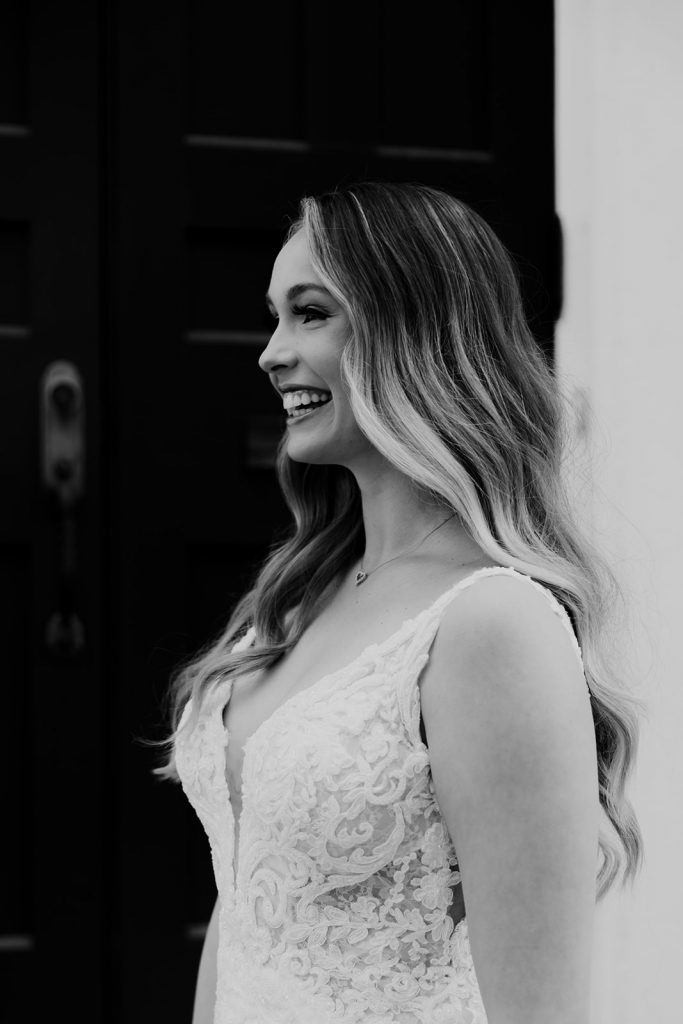 Black and white photo of bride profile photographed while smiling in