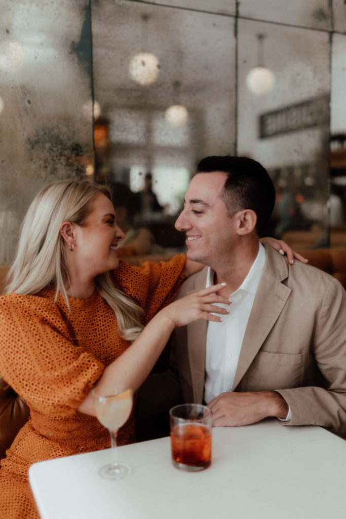 Couple having cocktails at their engagement photo session