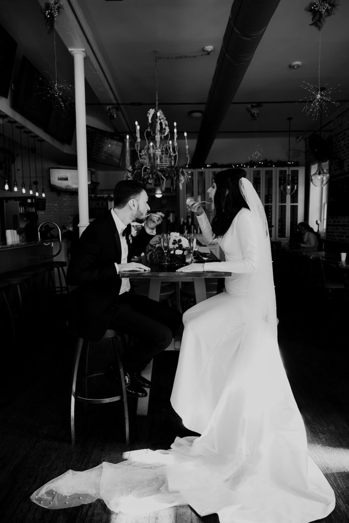Bride and groom sharing cake in a café after their Charleston elopement