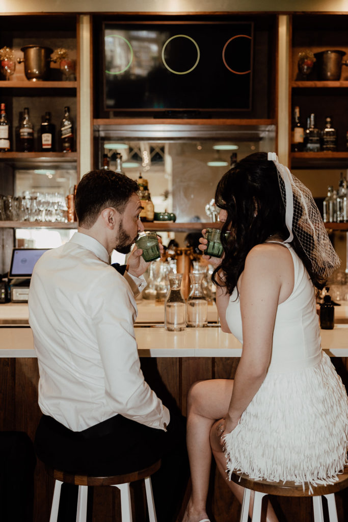 Bride and groom share a drink at a Carmella's in Charleston