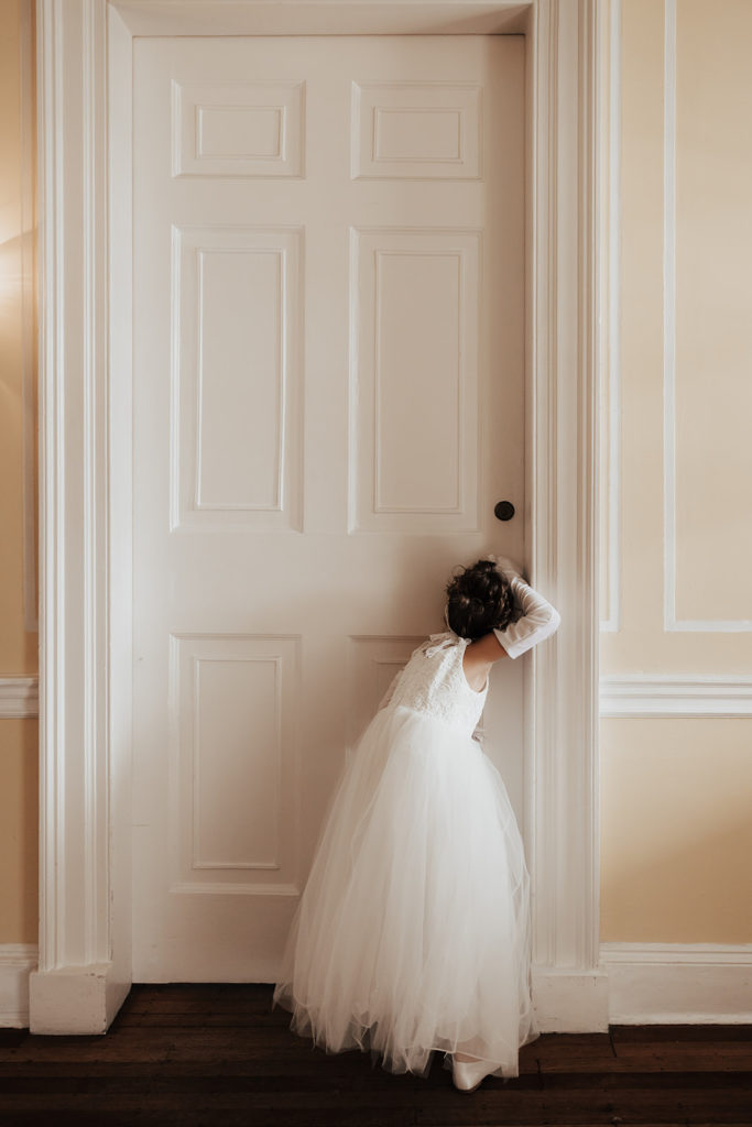 Flower girl trying to get a sneak peek of the bride