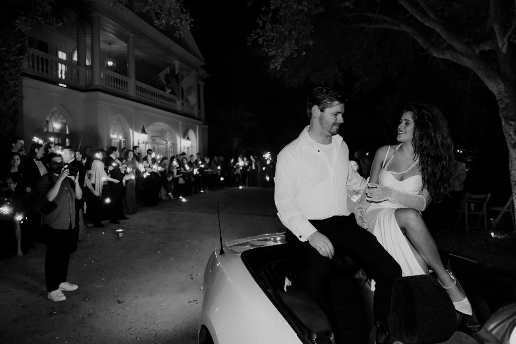 Bride and groom in getaway sportscar at their Lowndes Grove wedding