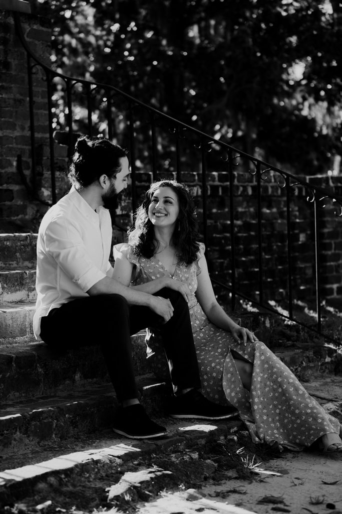 Couple sitting on stairs at Middleton Place, looking at each other madly in love