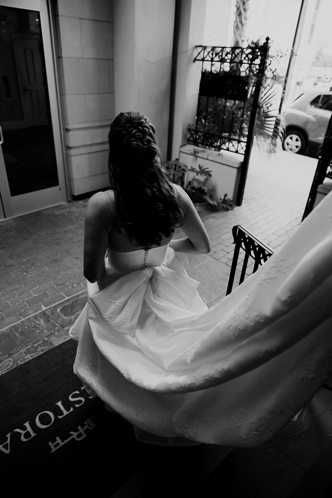 Bride with bow on dress walking down the stairs