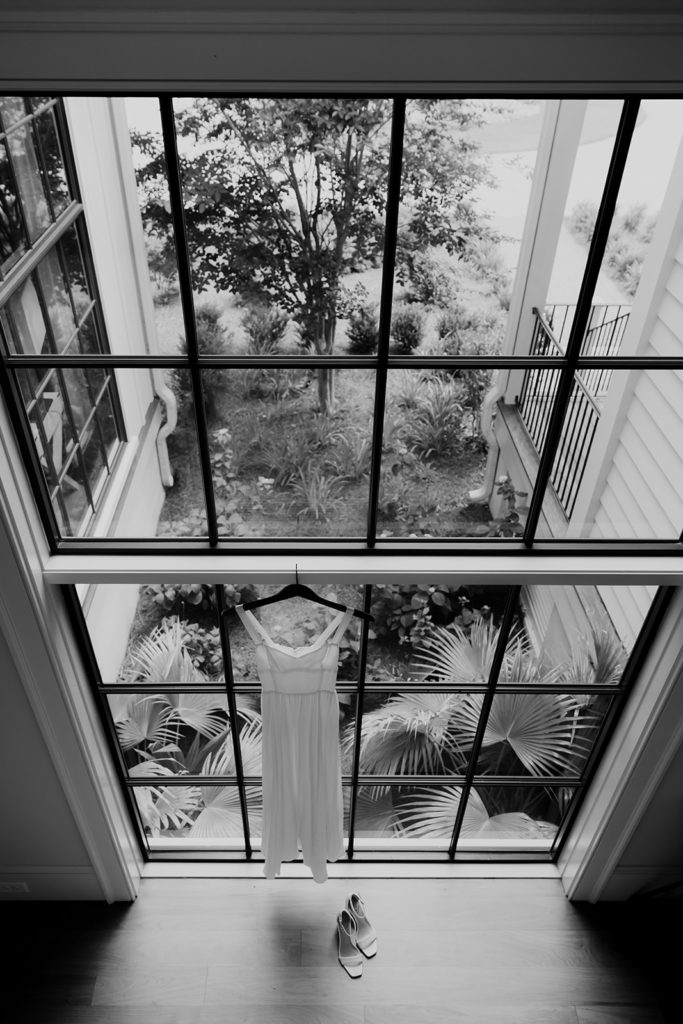 wedding dress hanging at large 2 story window for elopement