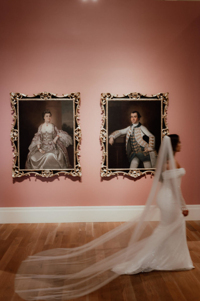 Bride passing paintings with long veil during bridal photo session