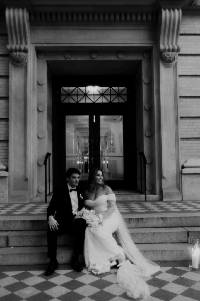 Bride and groom sitting in front of the gibbes museum for bridal portraits