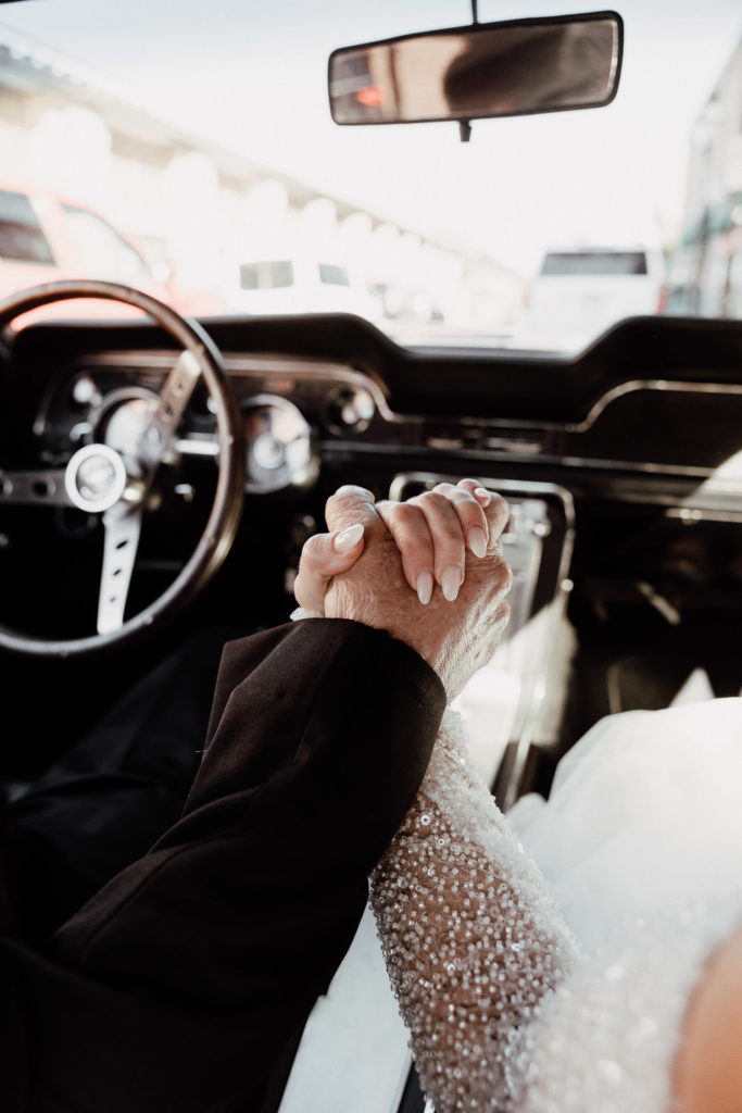 Bride holding on to fathers hand while driving to first look at hibernan hall in charleston