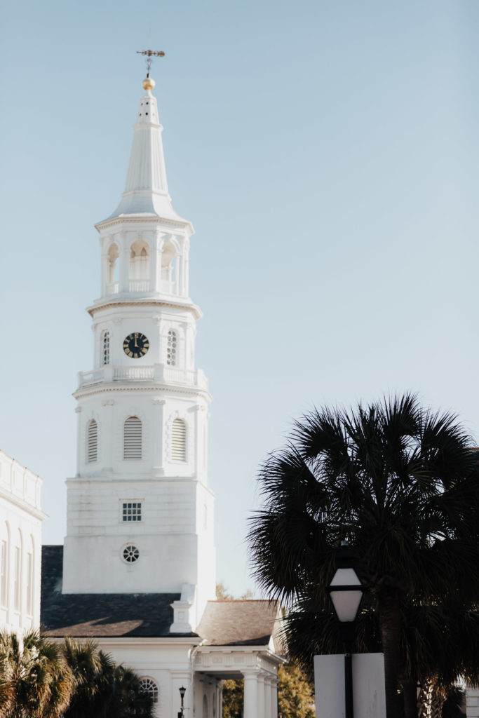 The white spire of St. Michael's Church in Charleston with Palmetto tree next to it