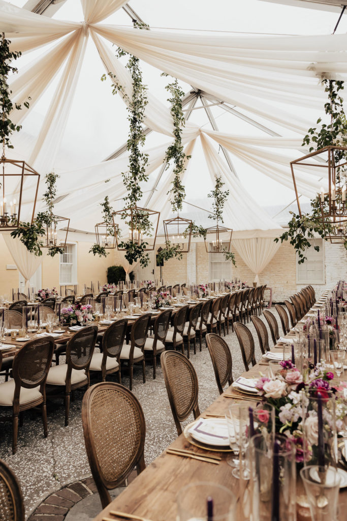 Reception tables set under elegant white tent at William Aiken house wedding