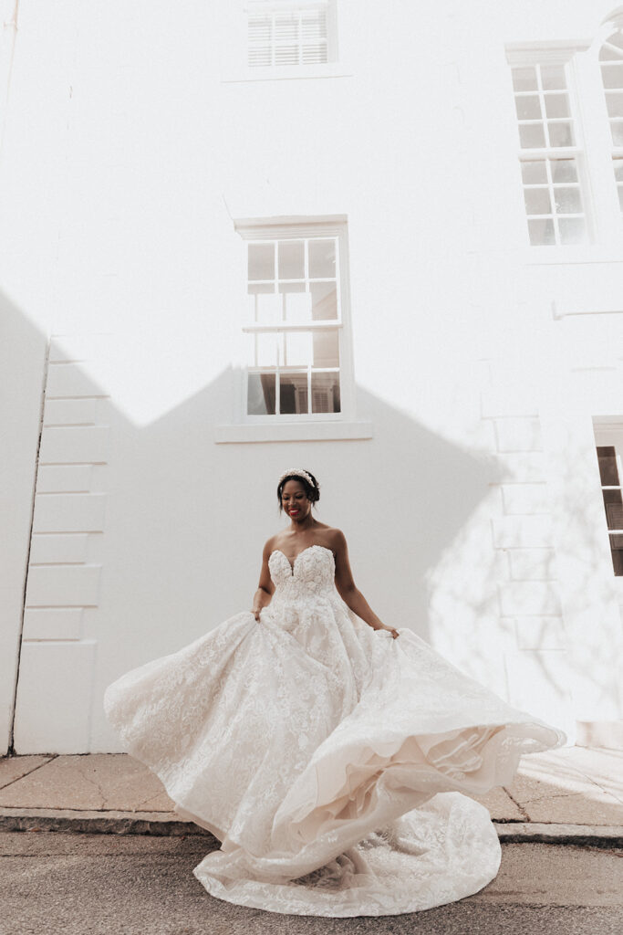Bride twirling in wedding dress on street during bridal photo session