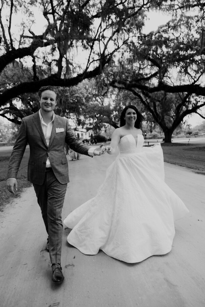 Black and whte photo of bride and groom under majestic oak trees in Charleston