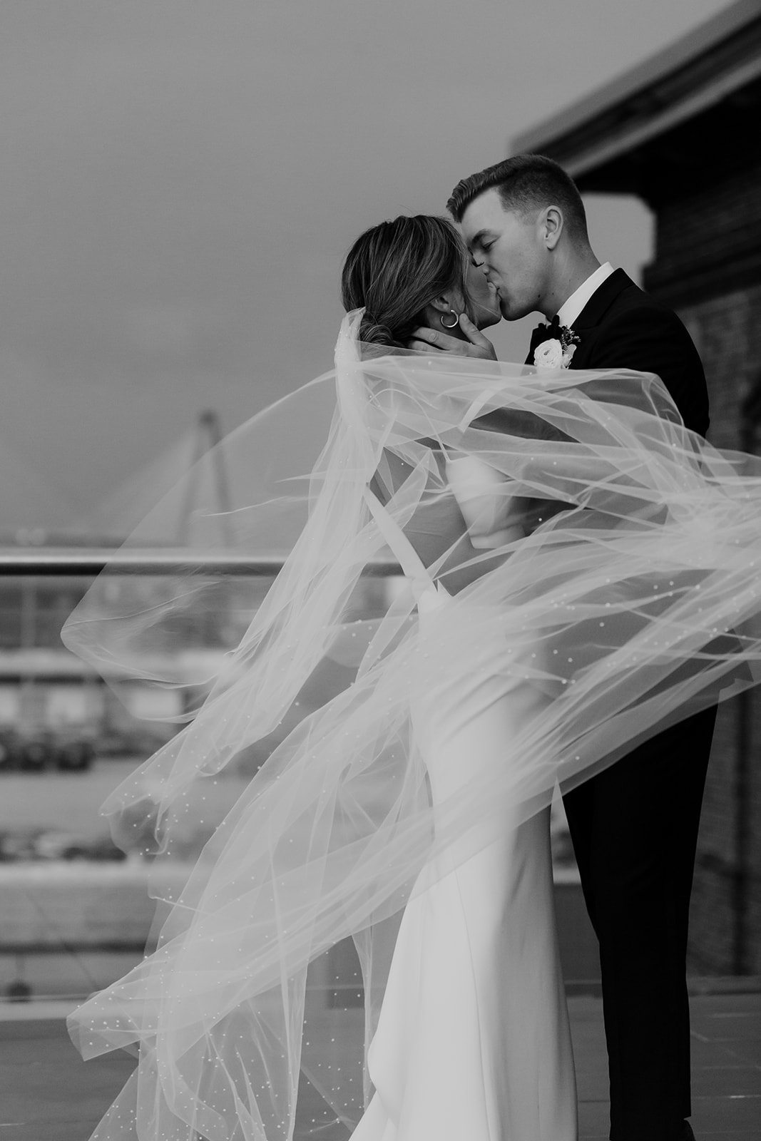 Black and white photo of couple at Cedar Room Wedding. Rooftop kiss.