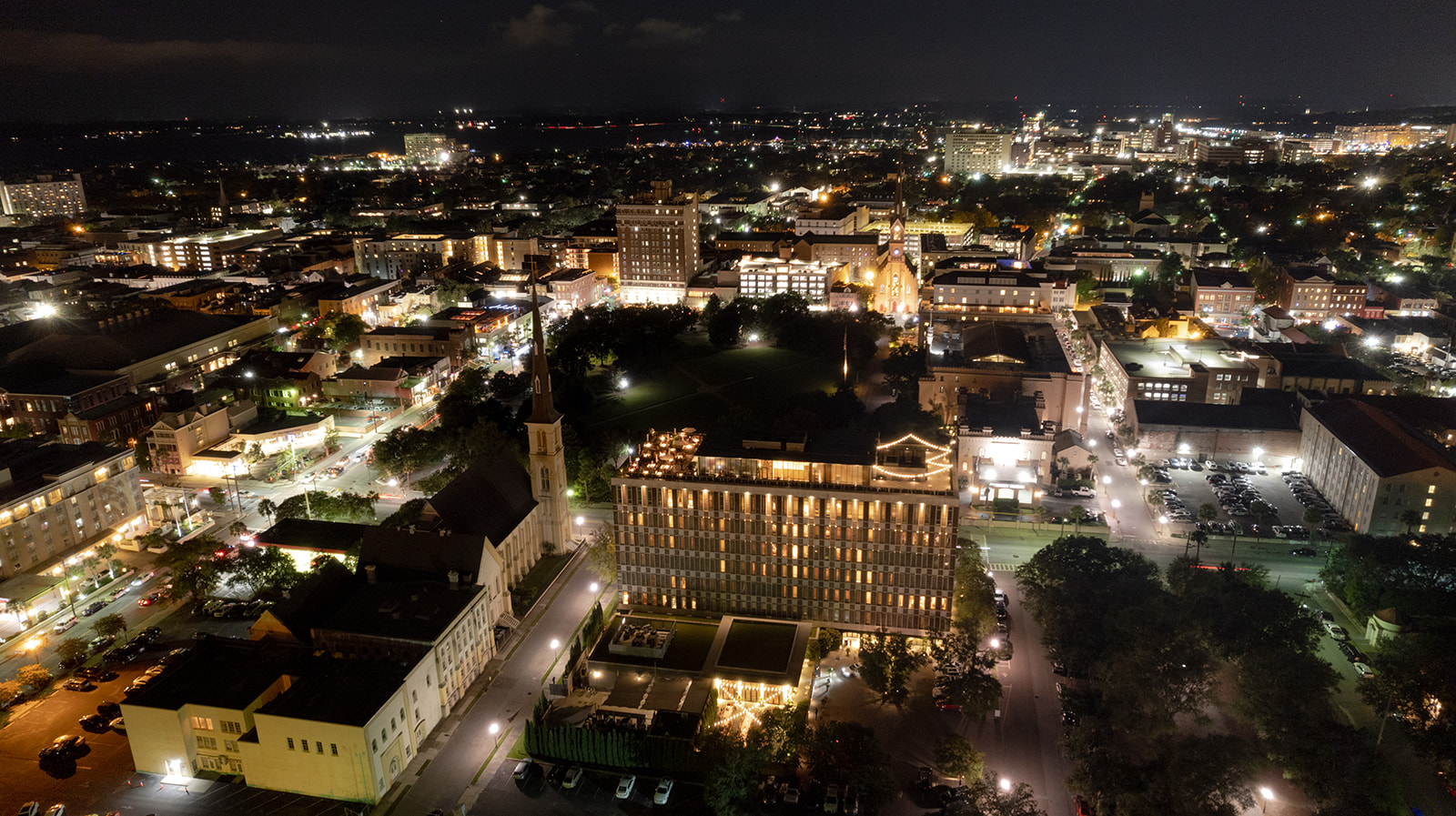 Aerial photo of Dewberry hotel and Charleston at night