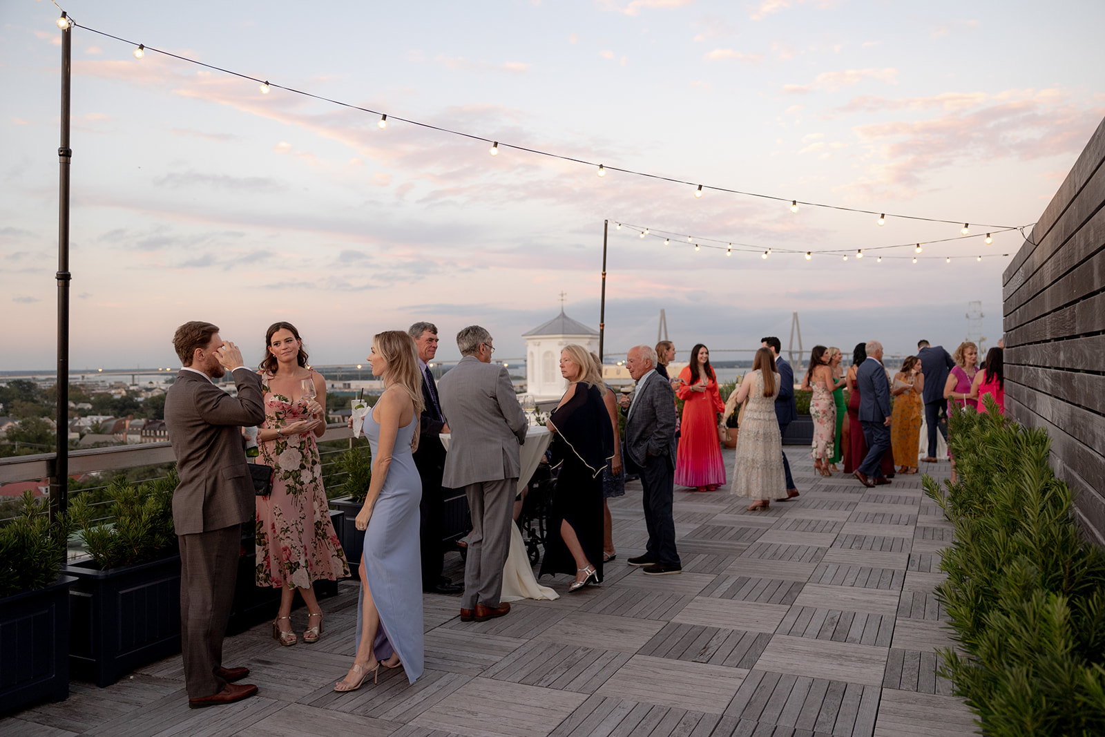 Wedding guests enjoy cocktail hour on the Dewberry hotel rooftop