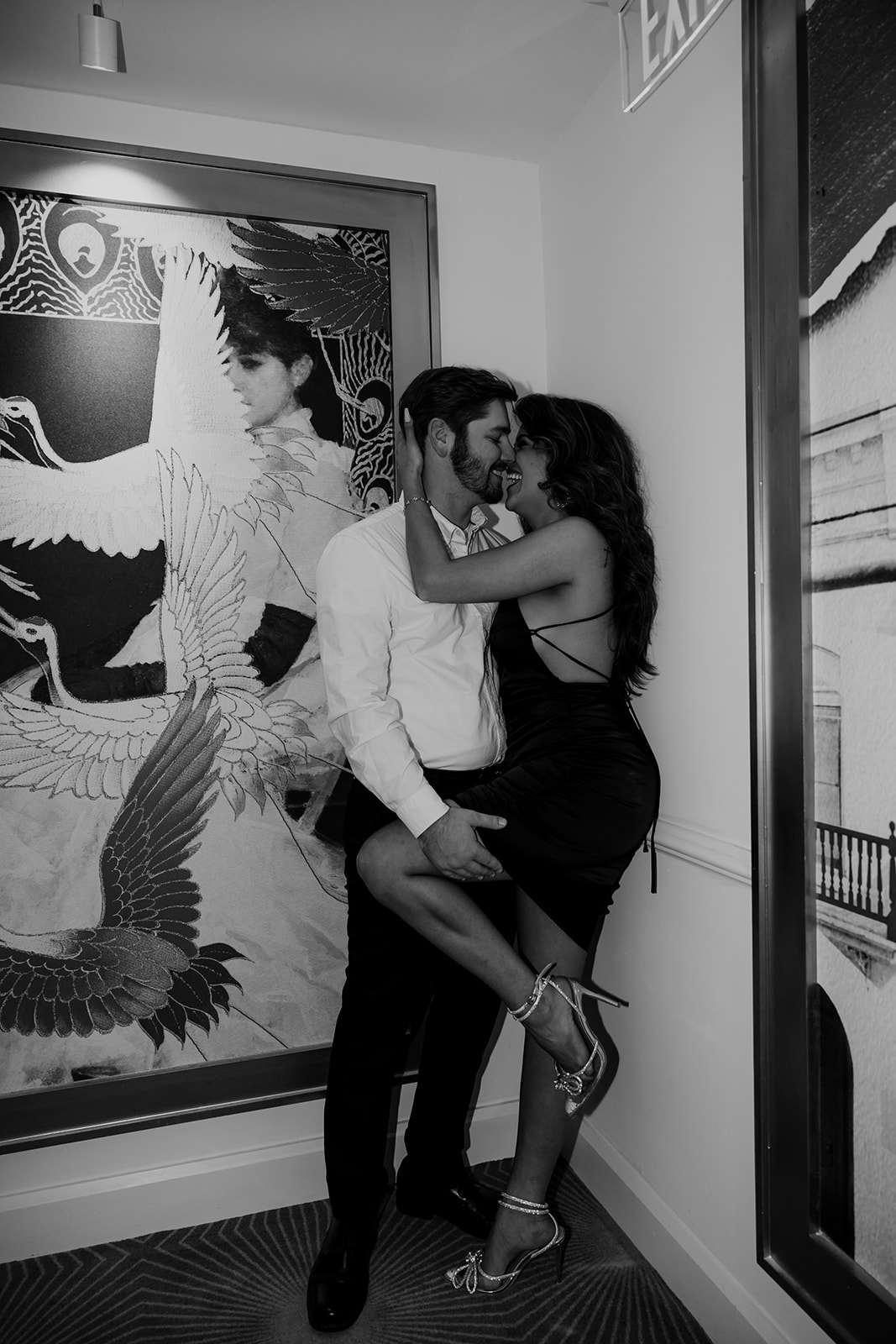 Intimate kiss in hallway of vendue Hotel Engagement Session. woman holding on to man's head. Man holding up one leg.