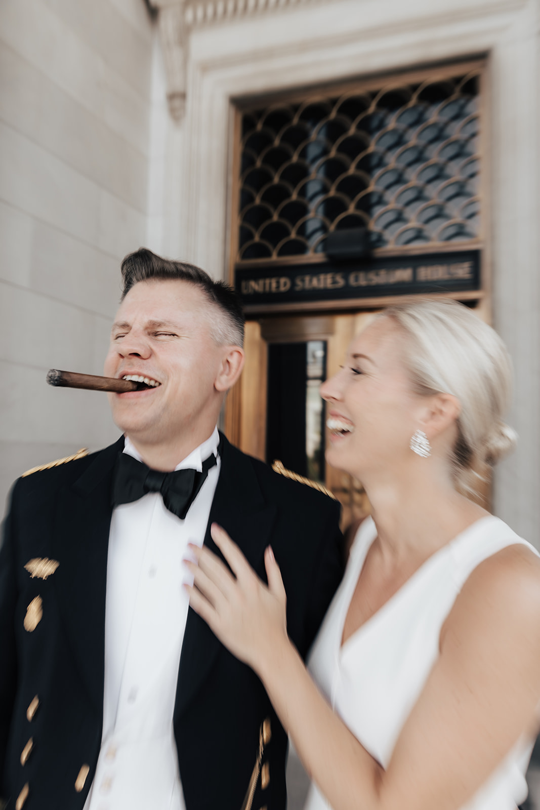 Man in military uniform and cigar in mouth next to woman in white dress posing for anniversary photos