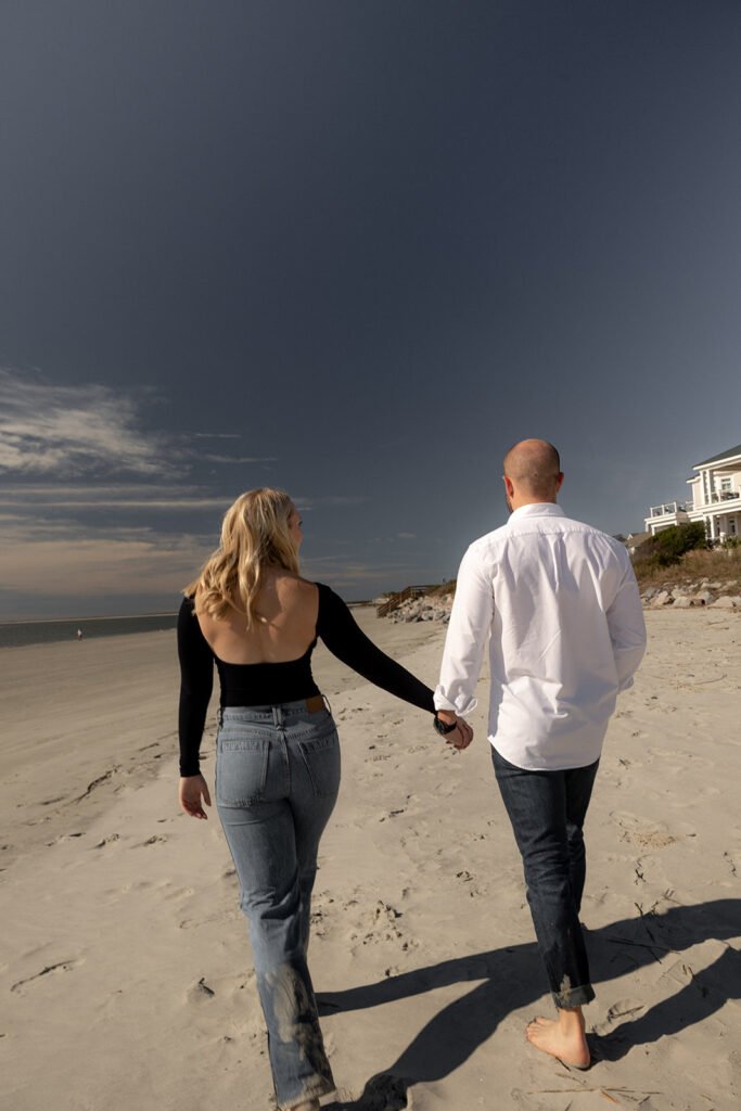 Couple at Seabrook Island Beach Engagement holding hand. Photographed from behind.