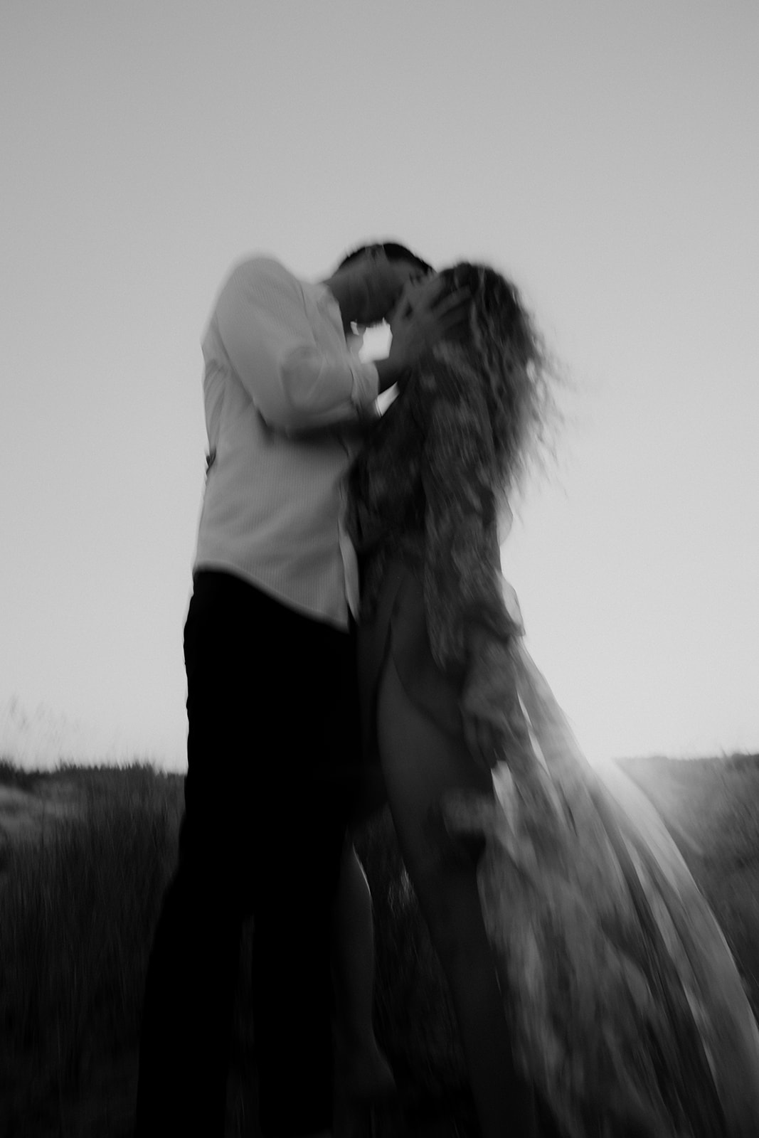 Artsy Charleston Beach Engagement Photo in black and white of couple sharing a kiss