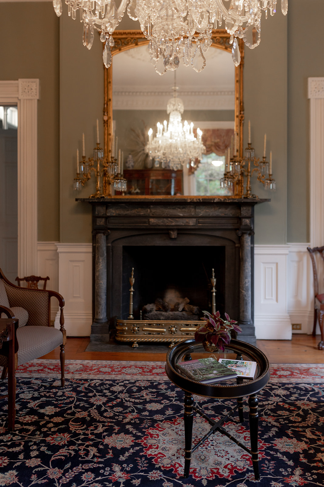 Fireplace at Gov. Thomas Bennett House. Mirror hung above it with chairs and small coffee table in the front.