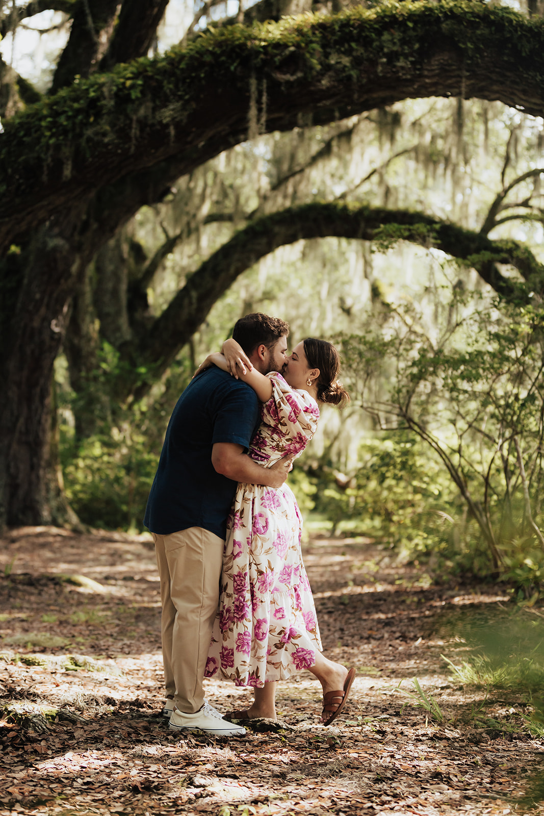 Couple sharing a kiss unde roak tress at magnolia plantation for engagement photos