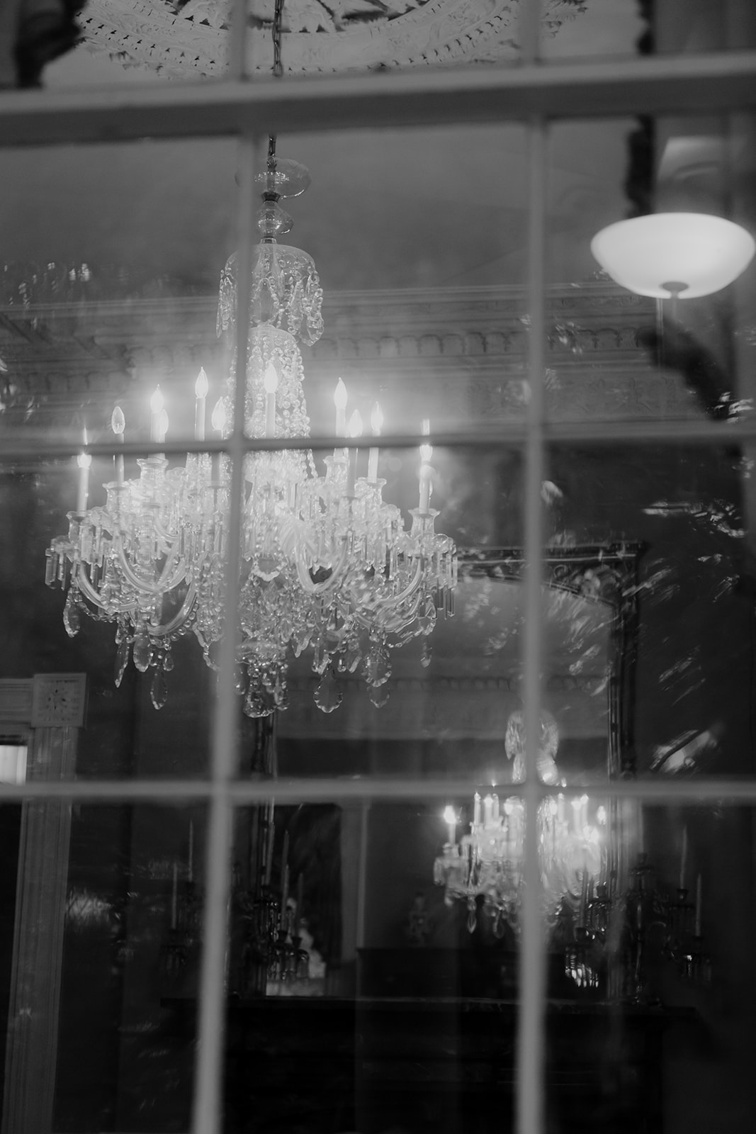Chandelier at Gov. Thomas Bennett House photographed from the outside during wedding celebration