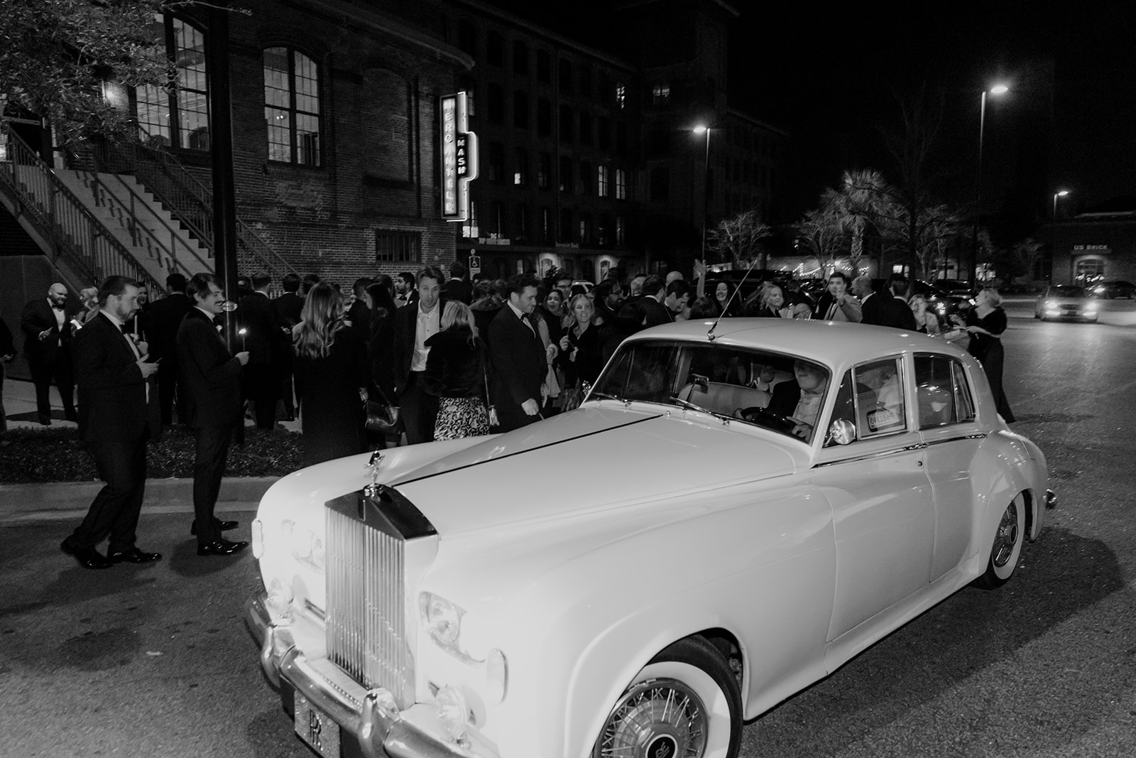 Bride and groom in Rolls Royce departing wedding in front of Cedar Room
