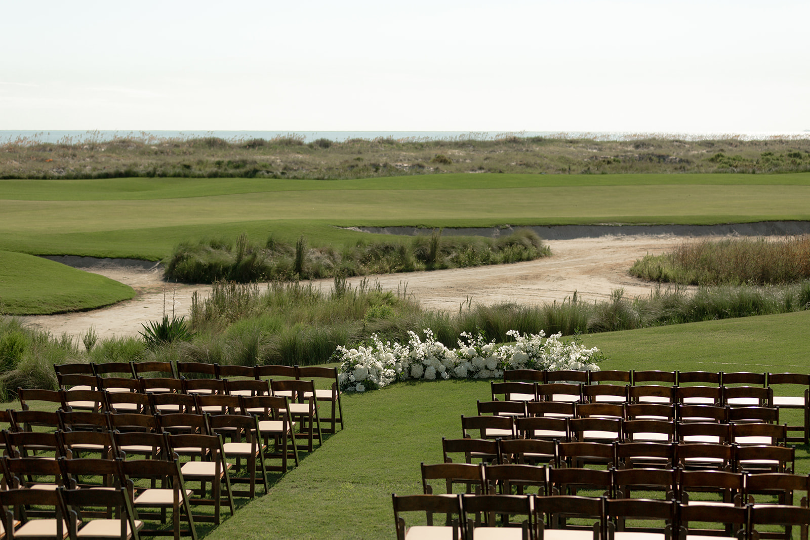 Wedding ceremony setup at Kiawah Island with Ocean Course in the background