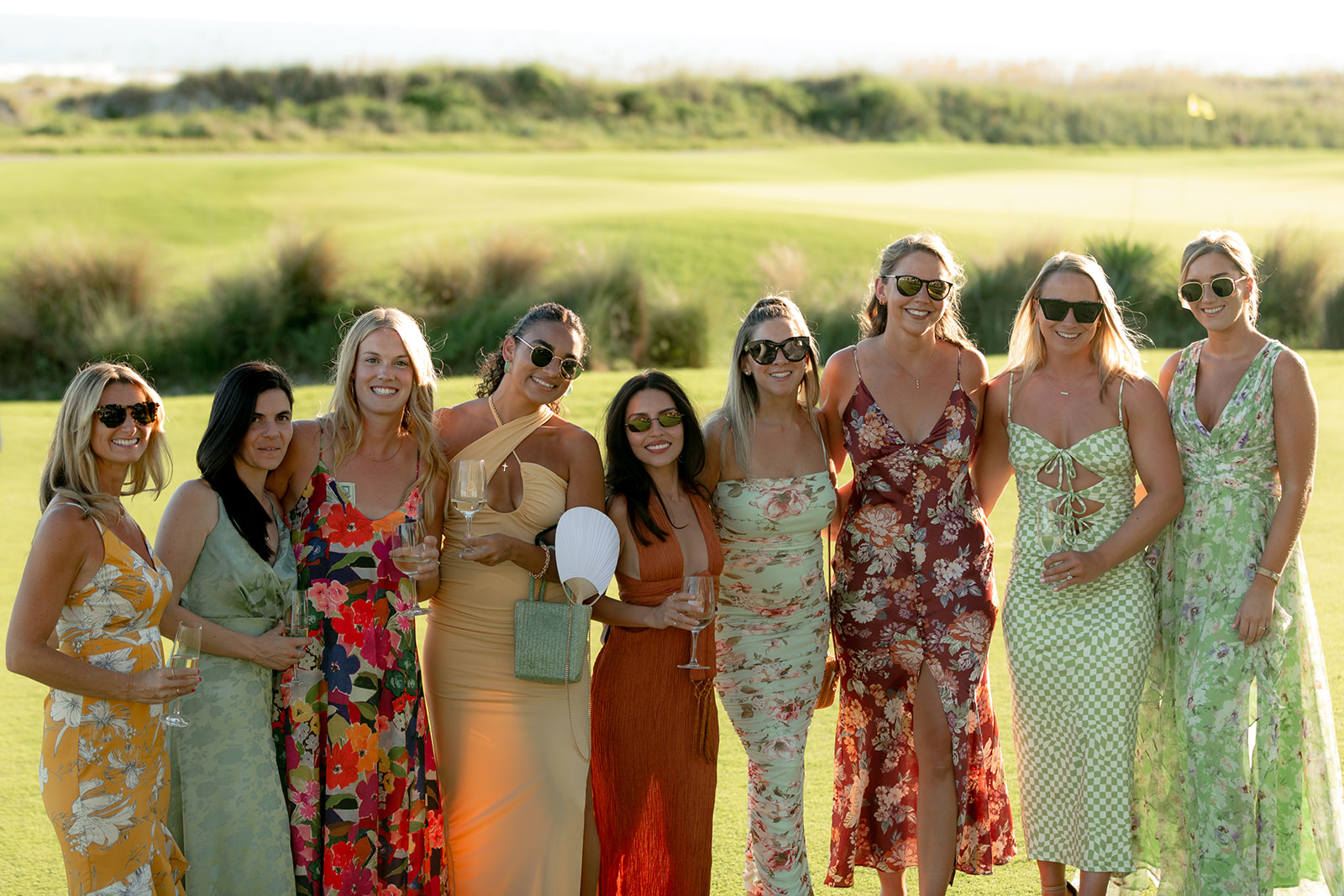 Group photo of female wedding guest in colorful dresses at Kiawah Ocean Course wedding