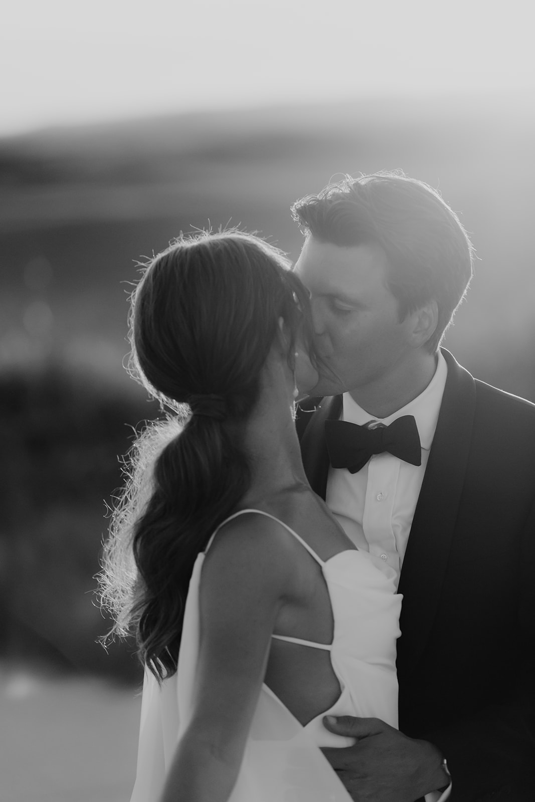 Black and white portrait of bride and groom kissing during sunset at Kiawah Ocean Course wedding
