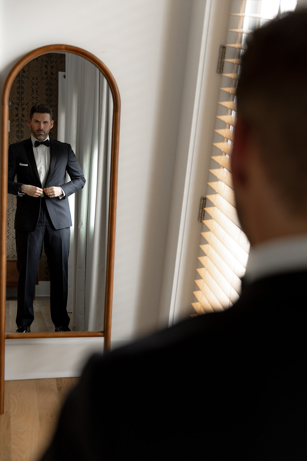 Groom looking into mirror getting ready for Charleston Elopement