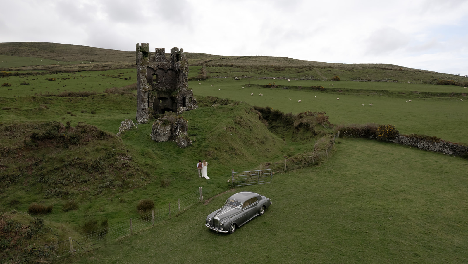 Bride and groom walking up the hill to the Rahinnane Castle for their Irlenad elopement
