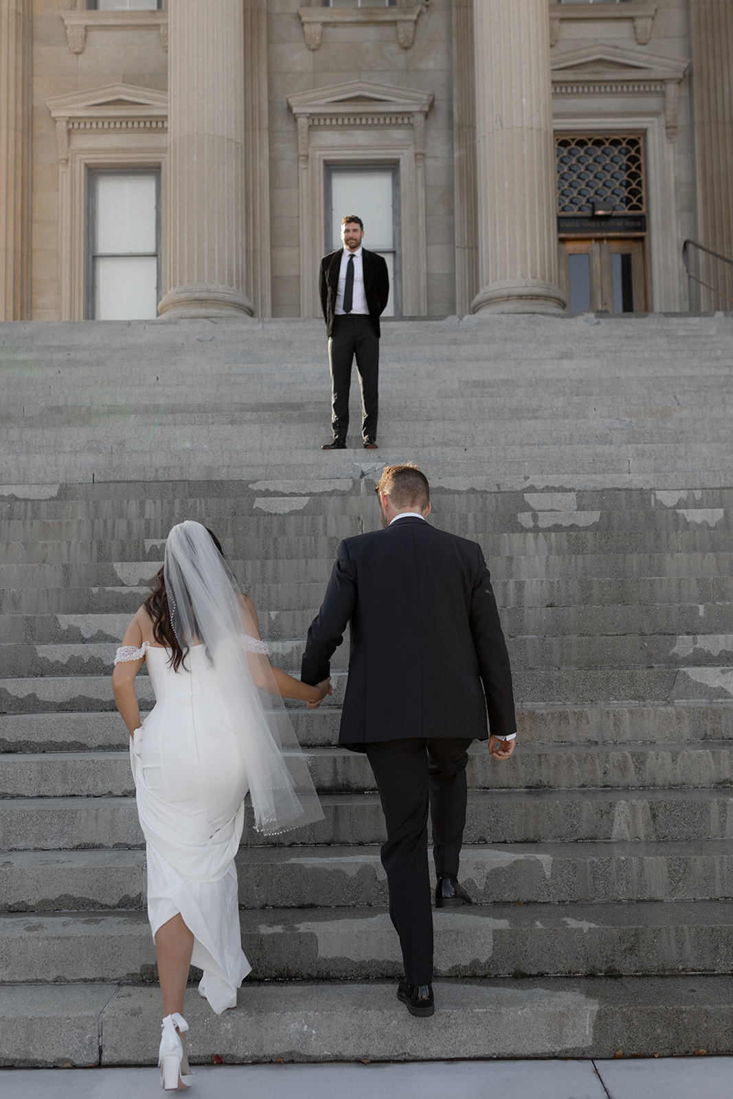 Bride and groom holding hands and walk up stairs to officiant for Charleston Elopement