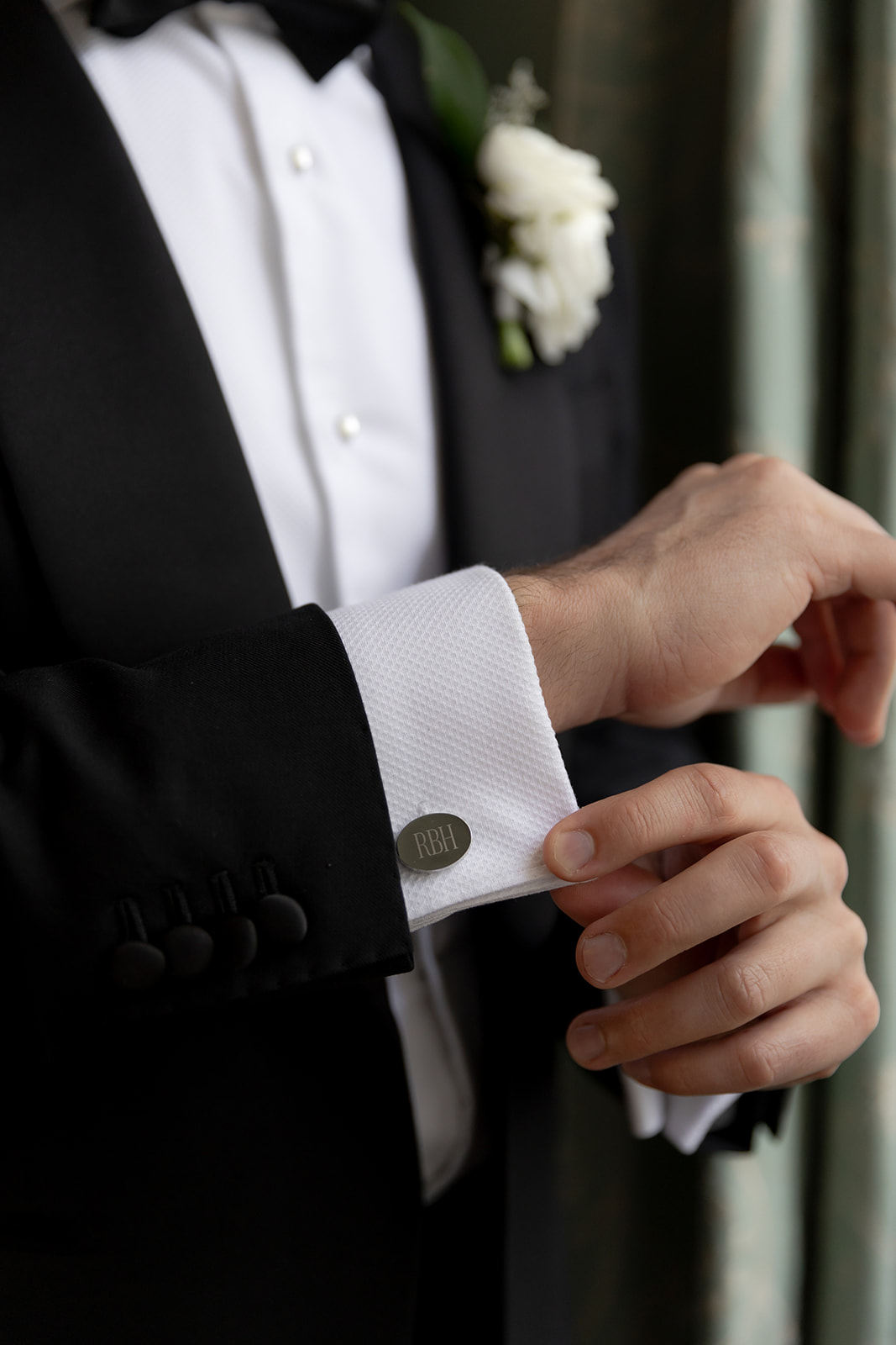 Groom showing monogram cufflinks for Lowndes Grove wedding