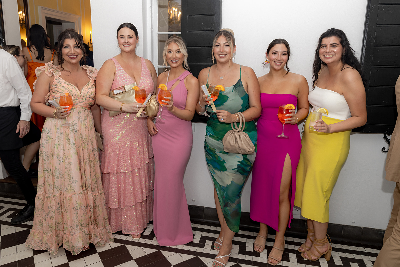 Colofrul wedding guest posing for camera while holding a Aperol Spritz