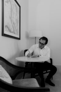 Groom writing his vows at hotel Dewberry hotel room in Charleston