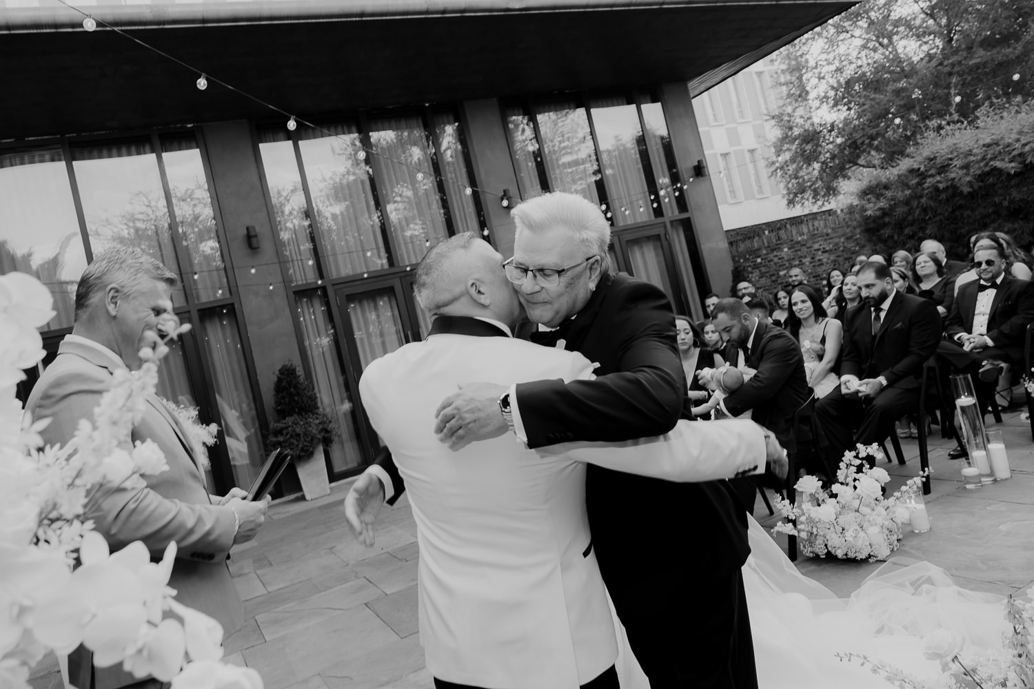 Father of th bride and groom hugging at the altar