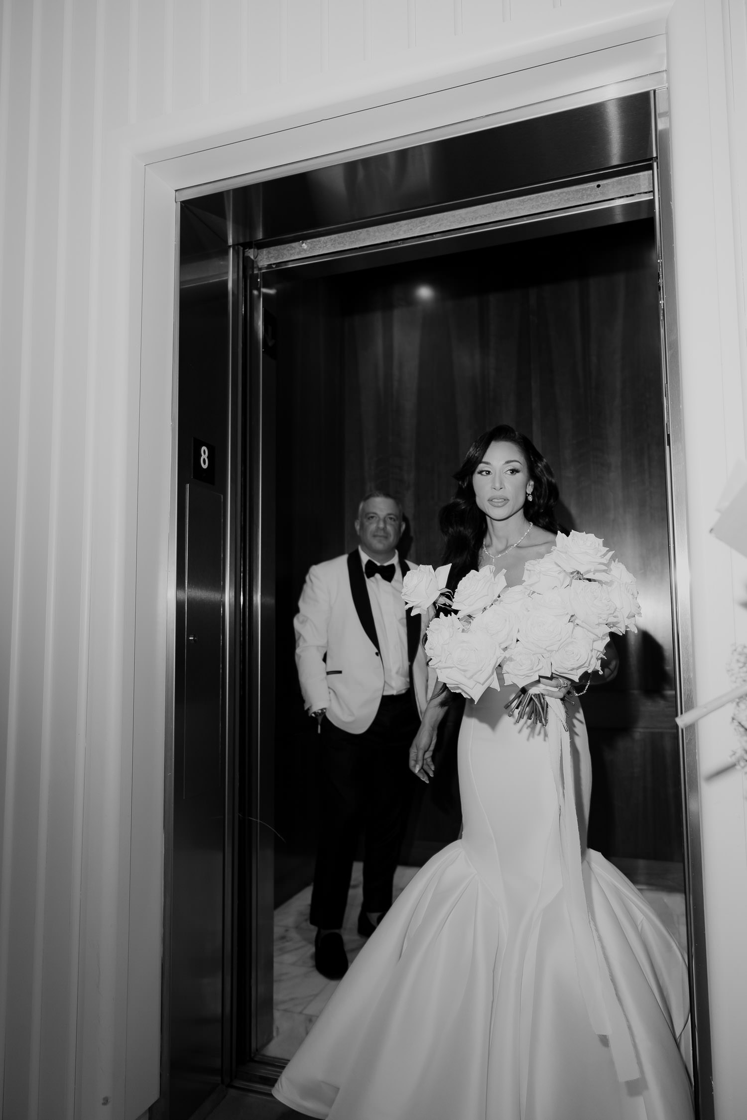 Black and white photo of newly weds at Dewberry wedding exiting the elevator