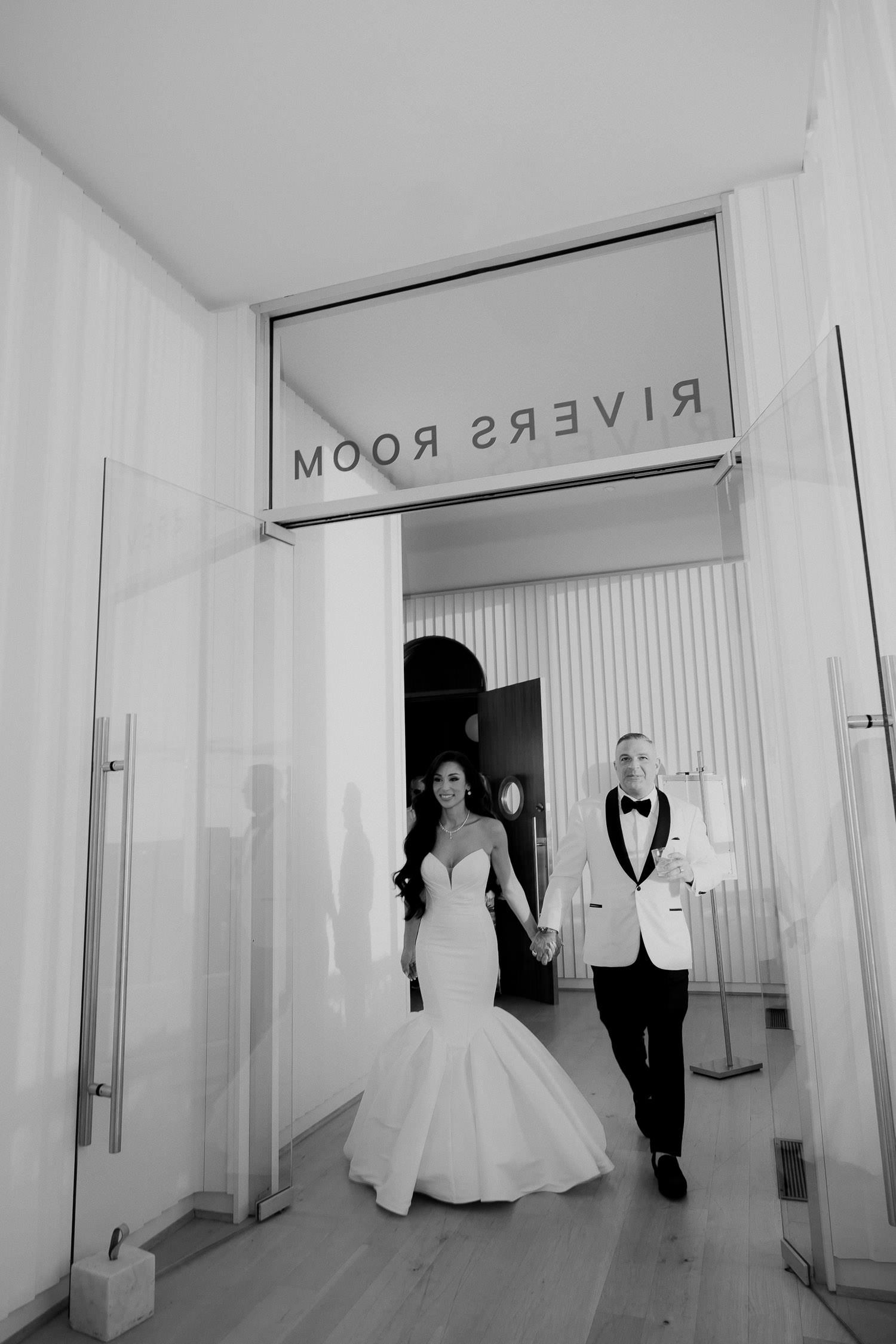 Bride and groom entering the rivers room at Dewberry wedding for cocktail hour