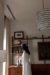 Bride pouring a glass of champagne at the getting ready suite