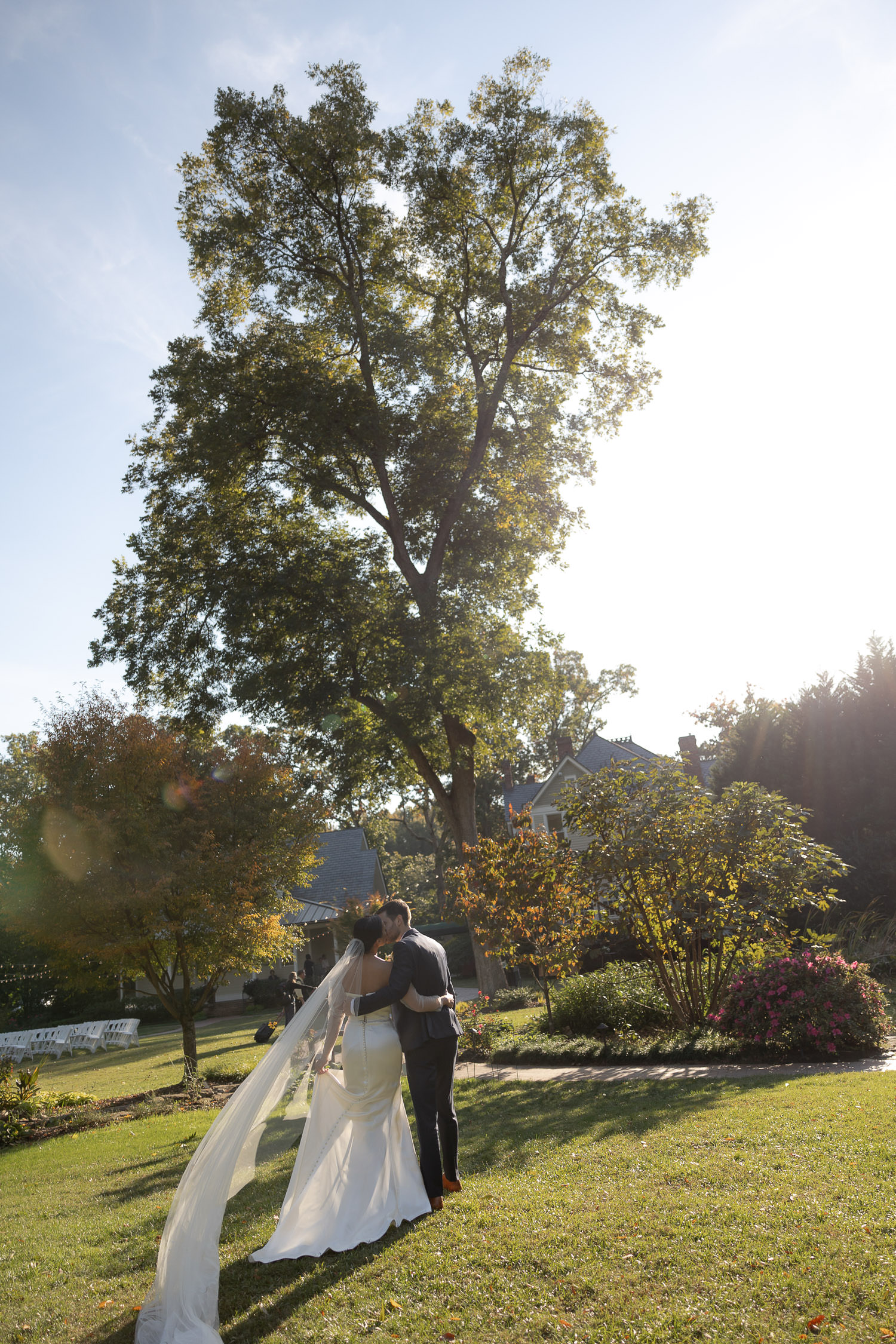 Bride and groom taking photos in garden at wedding at Alexander Homestead