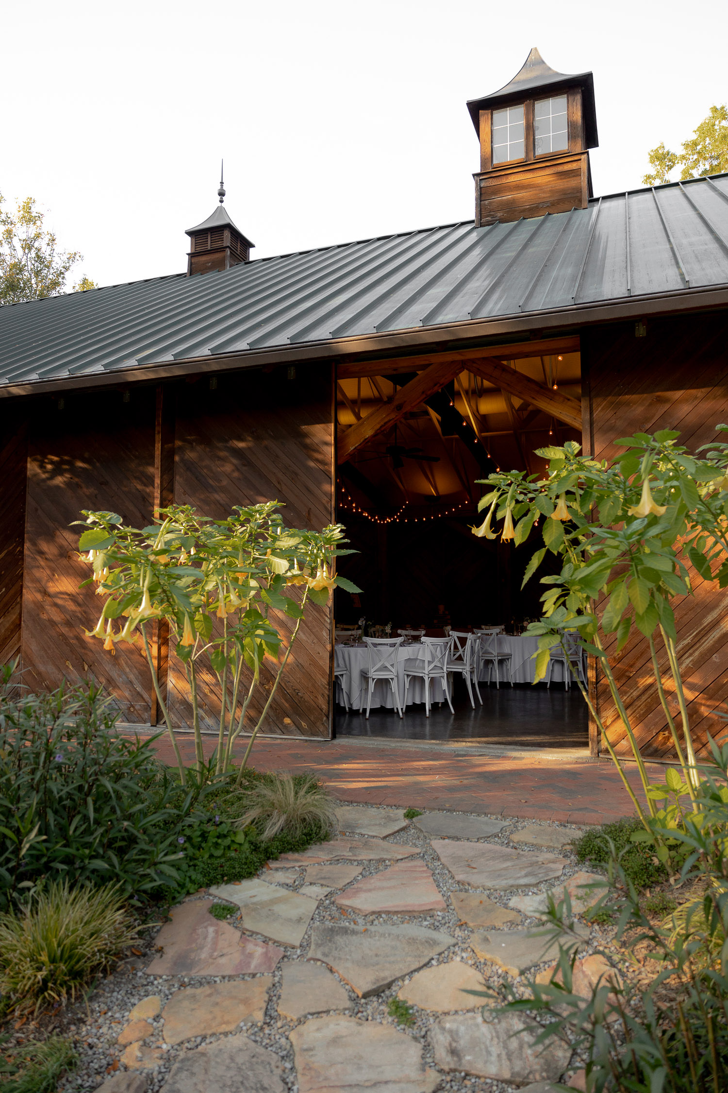 Entrance to barn wedding at Alexander Homestead lined up with yellow flowers