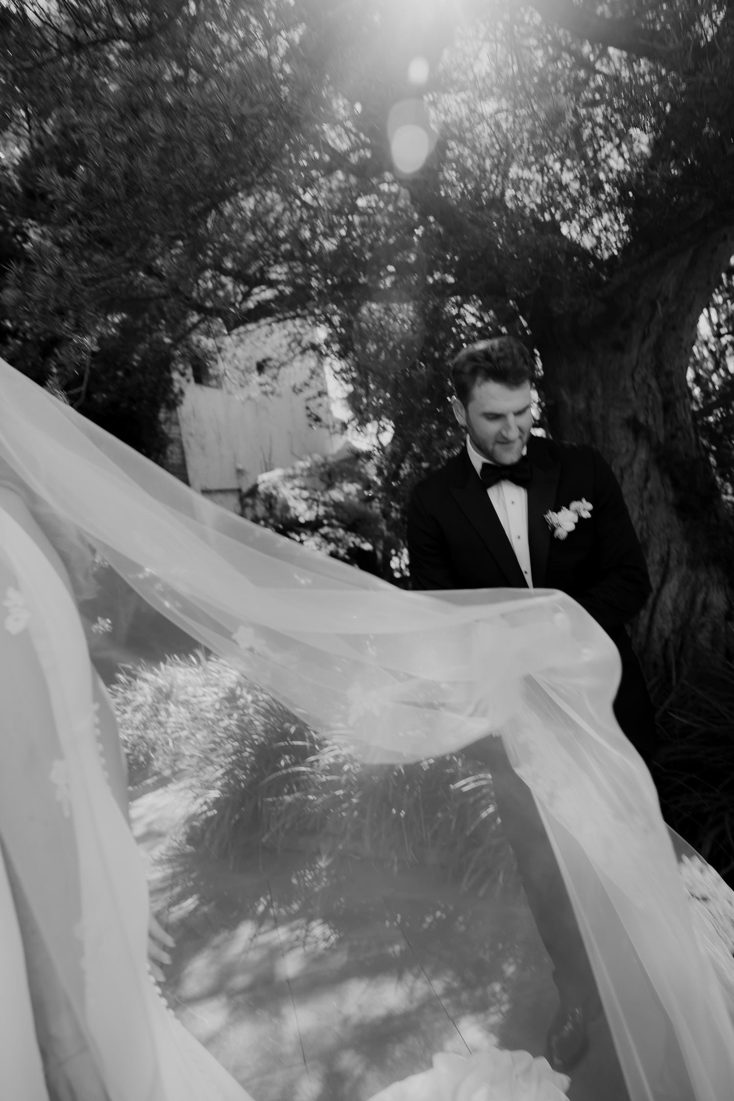 Groom carrying the bride's dress and vail