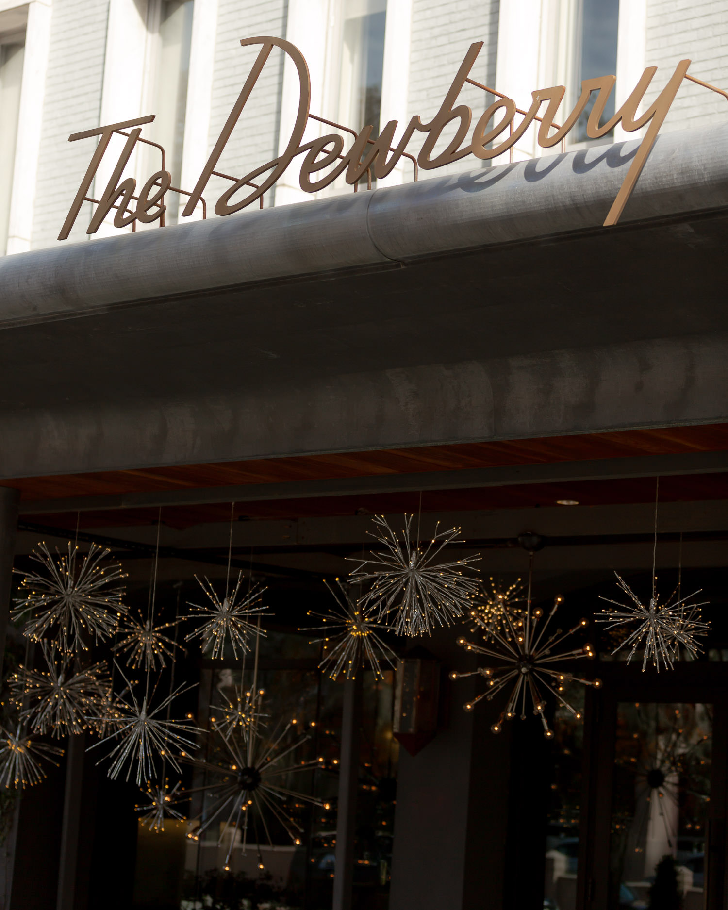 The Dewberry Charleston hotel front entrance with Christmas and winter decor. Stars hanging from ceiling.