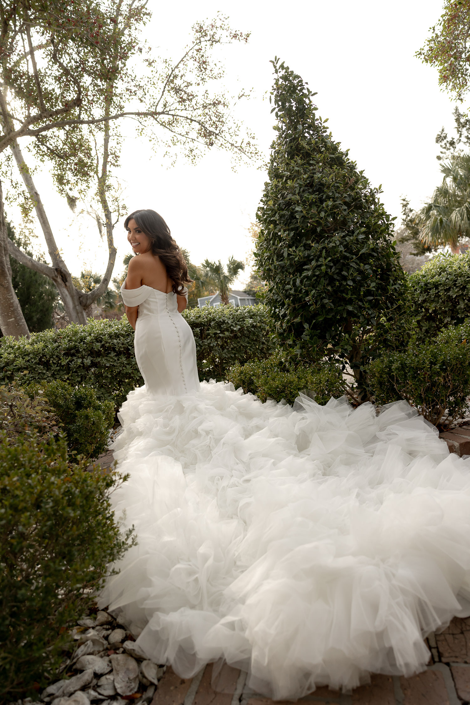 Bride unveiling her dramatic dress outside the Faber house in Charleston