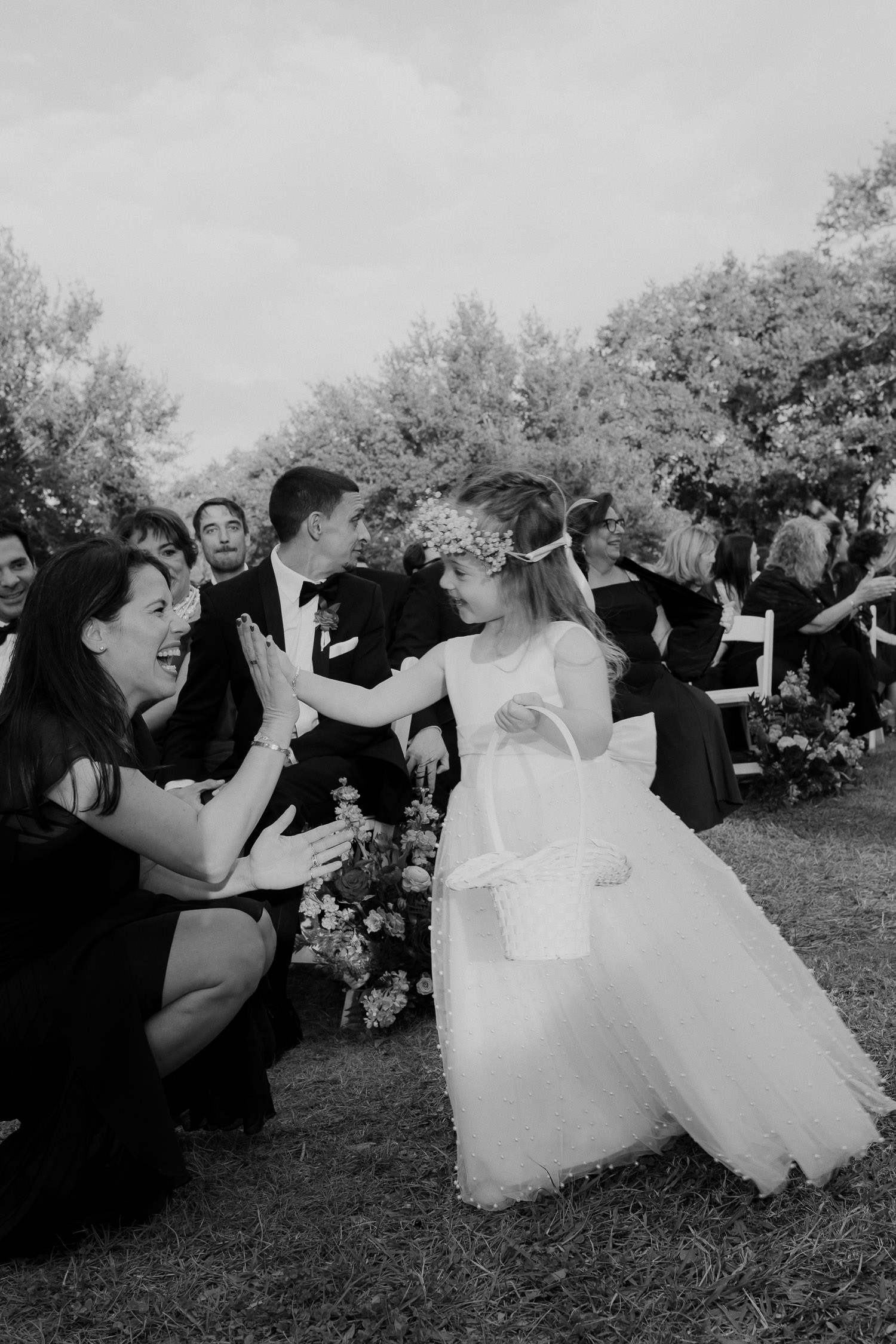 Flower girl gives high five to mother after walking down the aisle at Hot pink & Red wedding